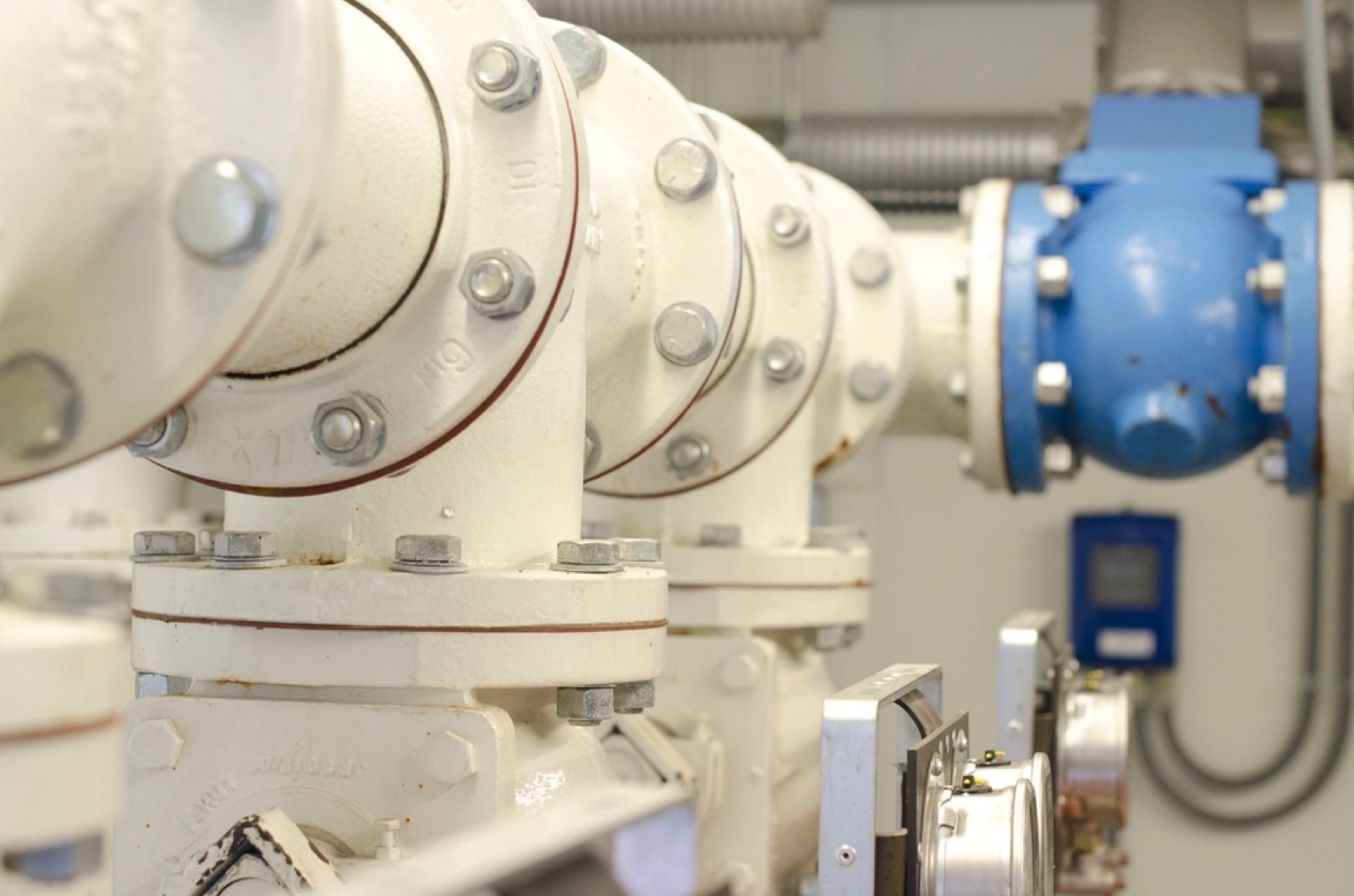 Flanged mains pipework with a valve and a flow transmitter