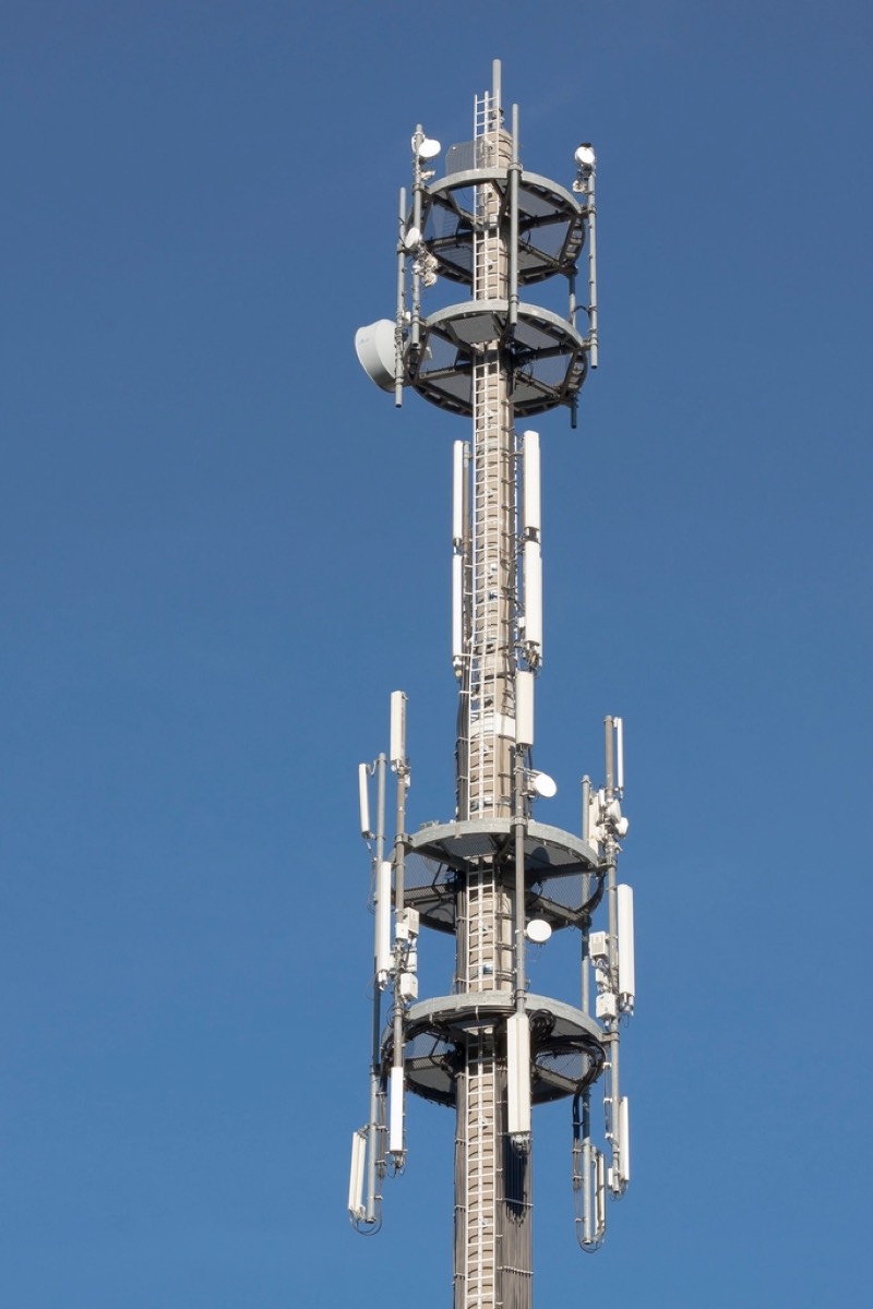 Cellular antennas on a mast against a clear sky